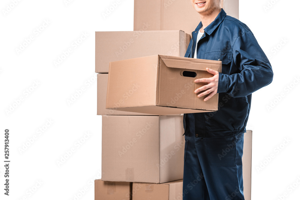 Wall mural cropped view of mover in uniform carrying cardboard box isolated on white