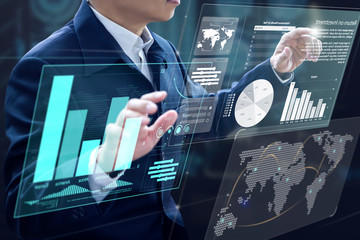 Businessman in front of virtual modern computer virtual touch screens analysing on investment risk...