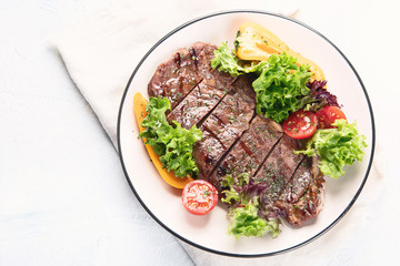 Grilled beef steak and fresh vegetables on plate