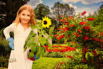 Beatifull girl with sunflower in the garden at summer day. Child relaxing in garden in sunny day....