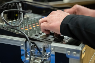 Fototapeta na wymiar Studio sound mixing board met handen aan de knoppen and selective focus