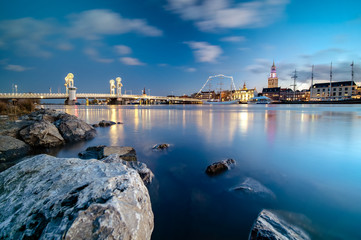 Nightfall with blue sky and long exposure above the old medieval city of Kampen in the Netherlands with its beautiful skyline