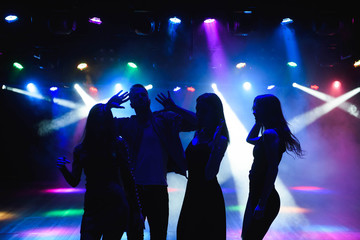 Fototapeta premium Young happy people are dancing in club. Nightlife and disco concept.