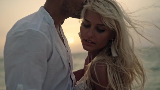 Sensual loving couple on the beach at sunset