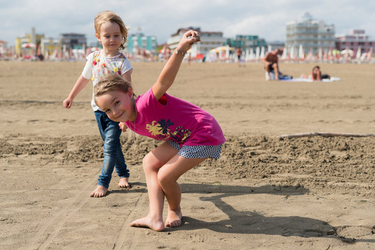 Two playful little girls on the beach