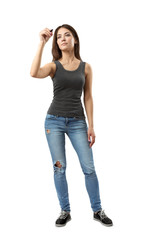 Young woman in gray sleeveless top and blue jeans standing and posing with marker in hand as if writing on invisible board isolated on white background.