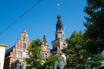 Fototapeta na wymiar Tower of Waag and stepped gable houses, Alkmaar, The Netherlands. Against blue sky