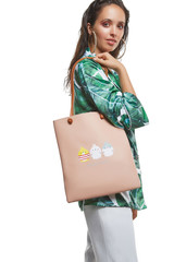 Three quarter side shot of lady, wearing shirt with tropical leaves print. The woman with slight...