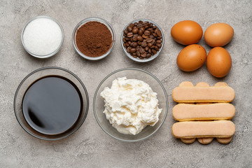 Fototapeta na wymiar Ingredients for cooking tiramisu - Savoiardi biscuit cookies, mascarpone, cheese, sugar, cocoa, coffee and egg