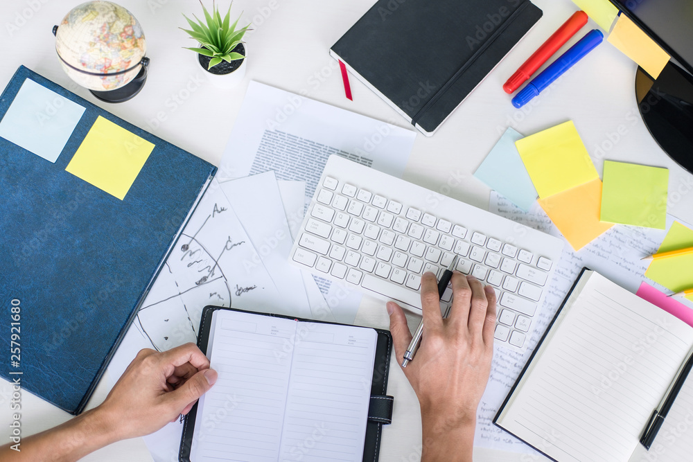 Poster businessman working writing business plan document and graphic designer with computer in office, top