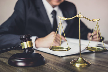 Judge gavel with Justice lawyers, Gavel on wooden table and Counselor or Male lawyer working on a documents. Legal law, advice and justice concept