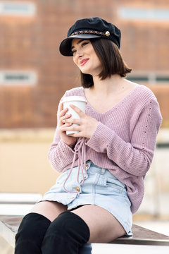 Portrait of fashionable young woman with coffee to go