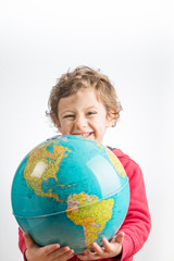 Child holding a globe in his arms.