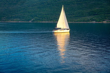 beautiful yacht with white sails on the calm water 