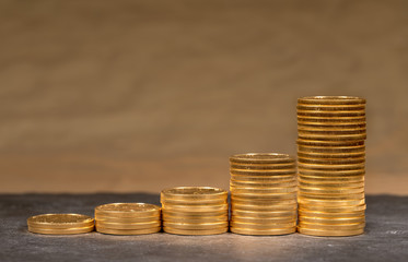 Concept illustration of growth of price of gold with stacks of gold eagle US Treasury golden coins