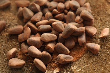 Pine nuts lie on a wooden board. Pine nuts contain many vitamins minerals and omega-3.