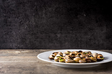 Escargots de Bourgogne. Snails with herbs and garlic butter on a plate. Copyspace