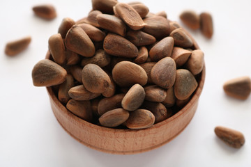 Obraz premium Pine nuts poured into a round plate. Pine nuts contain many vitamins minerals and omega-3.