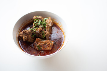 Pork bone in spicy soup served on white table in canteen