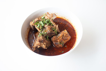 Pork bone in spicy soup served on white table in canteen