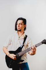 Obraz premium Detail of the fingers of a guitarist placed on the fret of the mast of the guitar playing a chord doing Tapping.