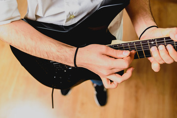 Detail of the fingers of a guitarist placed on the fret of the mast of the guitar playing a chord...