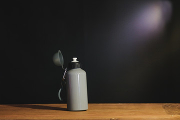 Still life water bottle and light ray on table.
