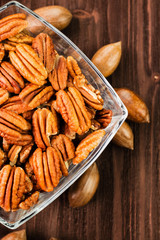 Pecan nuts in the shell with pecan kernel on wooden background