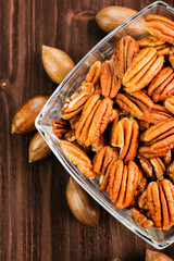 Pecan nuts in the shell with pecan kernel on wooden background