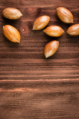 Pecan nuts in the shell on wooden background
