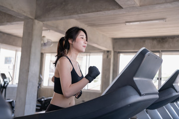 Fototapeta premium Exercise concept. Attractive young sports woman is working out in gym. Doing cardio training on treadmill.