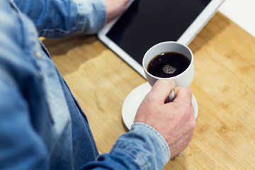 Hombre tomando un café y con tablet