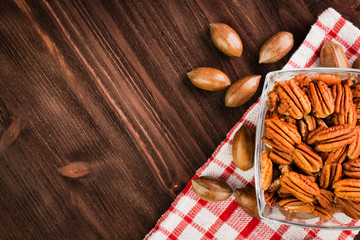 Pecan nuts in the shell with pecan kernel on wooden background