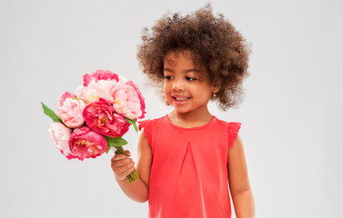 childhood and people concept - happy little african american girl with flowers over grey background