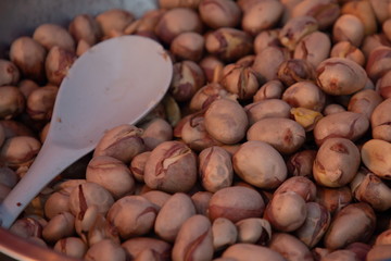 heap of jackfruit seeds and white spoon .