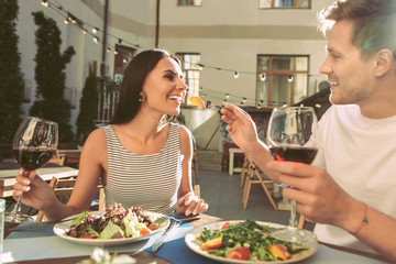 Smiling short-haired man with glass of red wine in one hand
