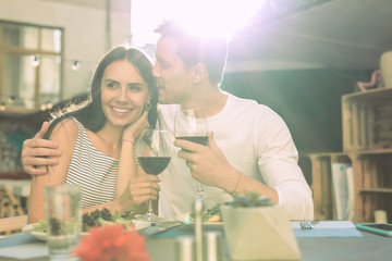 Caring good-looking man in white shirt hugging his long-haired partner