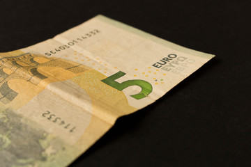 5 Euro banknote on a dark background. Close up. The concept of savings.