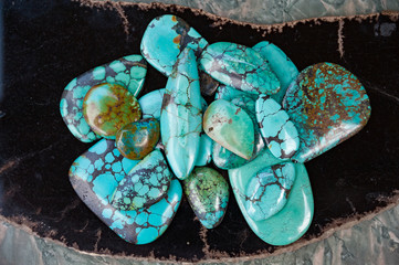 Pile of polished turquoise stones on black surface
