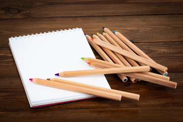 Blank notepad and pencil color on wooden blackground