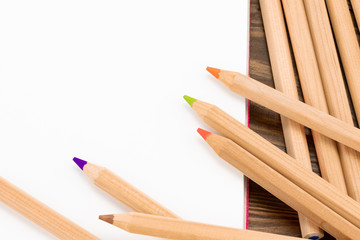 Fototapeta premium Blank notepad and pencil color on wooden blackground