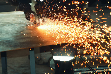 Bright sparks from cutting metal with a carbon-slave machine in the workshop room. Work with the tool in production.