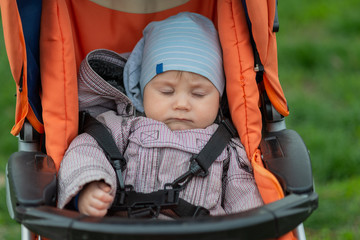 Cute baby boy sleeping in a stroller