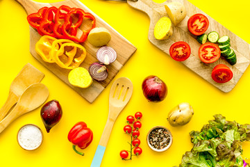 Fresh food ingredients for vegetarian kitchen on yellow background top view