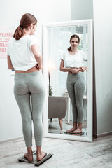 Young woman feeling dissatisfied with her figure