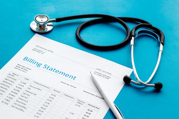 medical treatment bill, calculator and phonendoscope on blue background