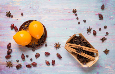blue wooden background with cinnamon, anise, dog rose  and lemon