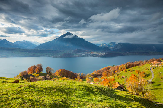Scenic view of Niesen mountain and Lake Thun against cloudy sky