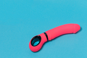 Erotic pleasure toy on a blue background. Sex gadget and masturbation device. A pink rubber and...