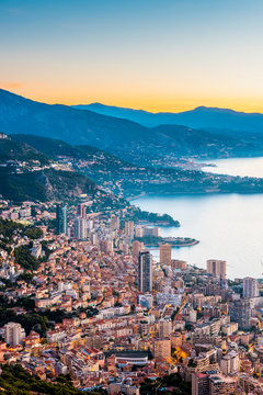 High angle view of Monaco cityscape with mountains at sunrise